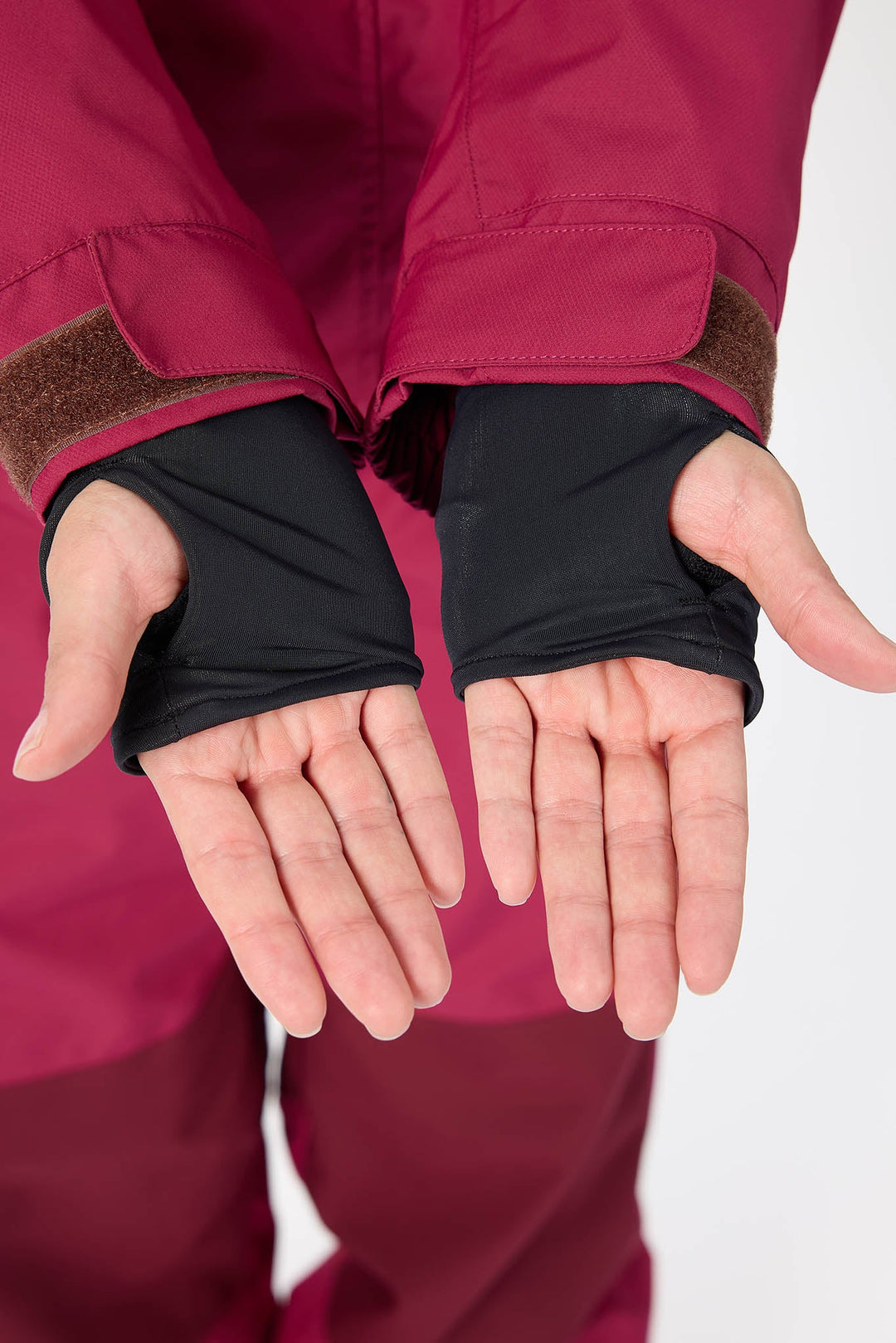 Person wearing a red jacket with black thumb grabbing on a white background
