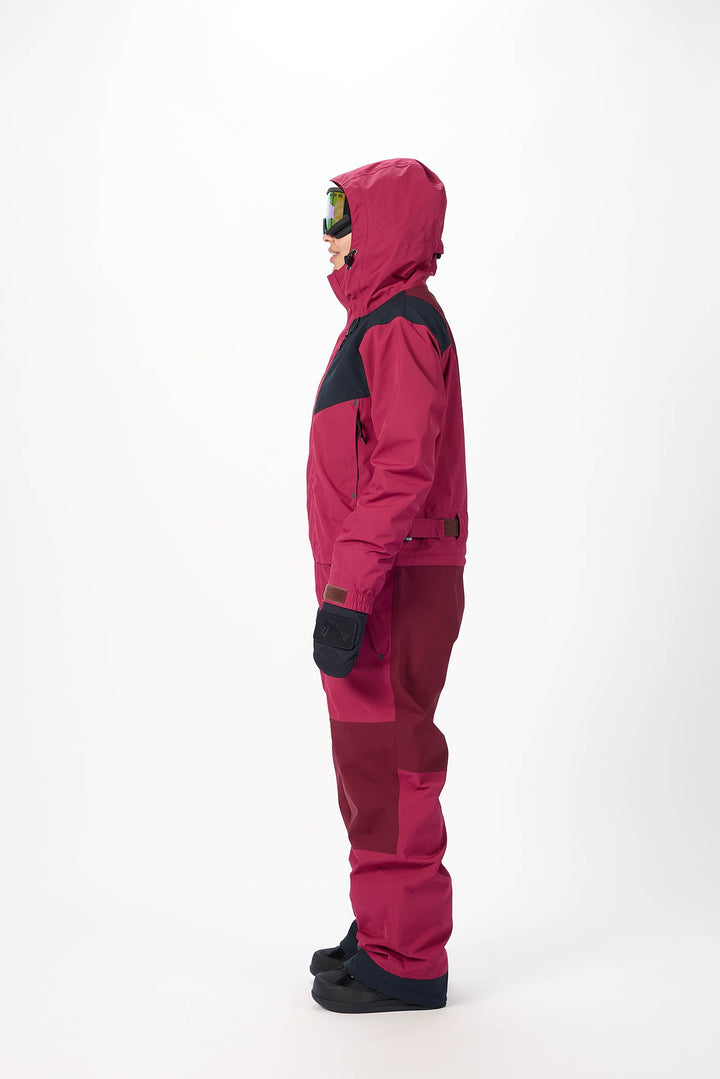 Person wearing a pink snowsuit with black accents on a white background