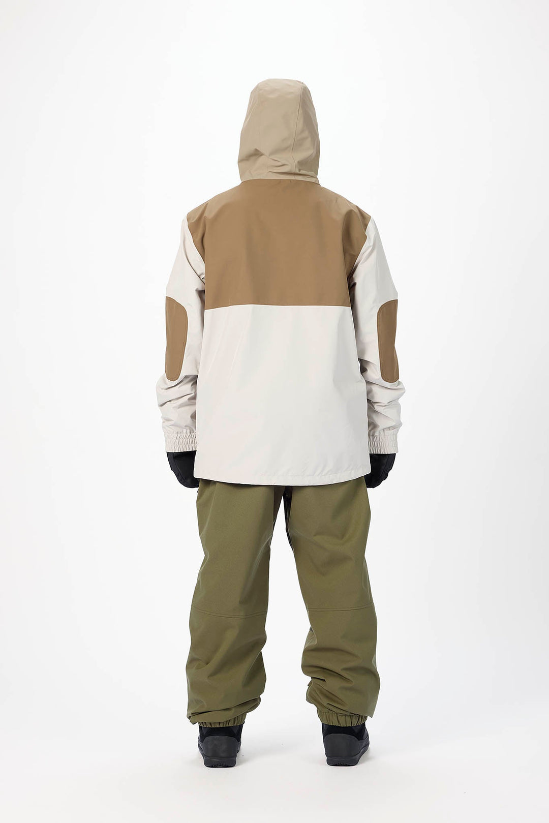 Person wearing a two-tone snowboarding jacket and pants on a white background