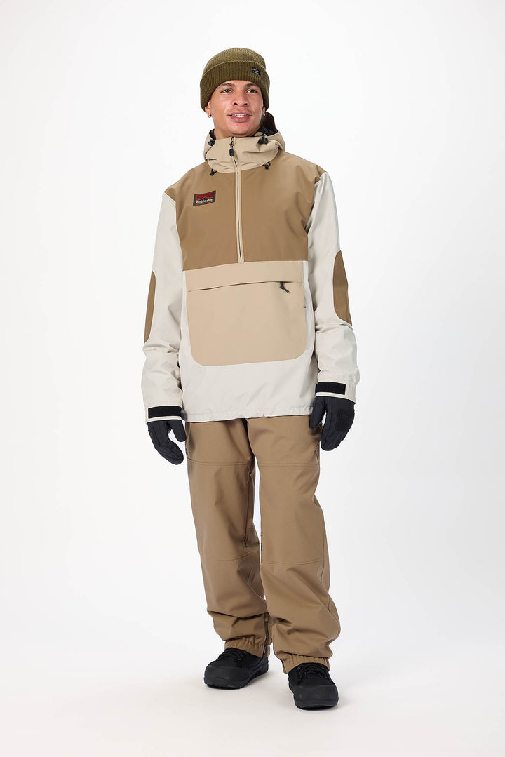 Person wearing a beige and white snowsuit with a beanie on a white background
