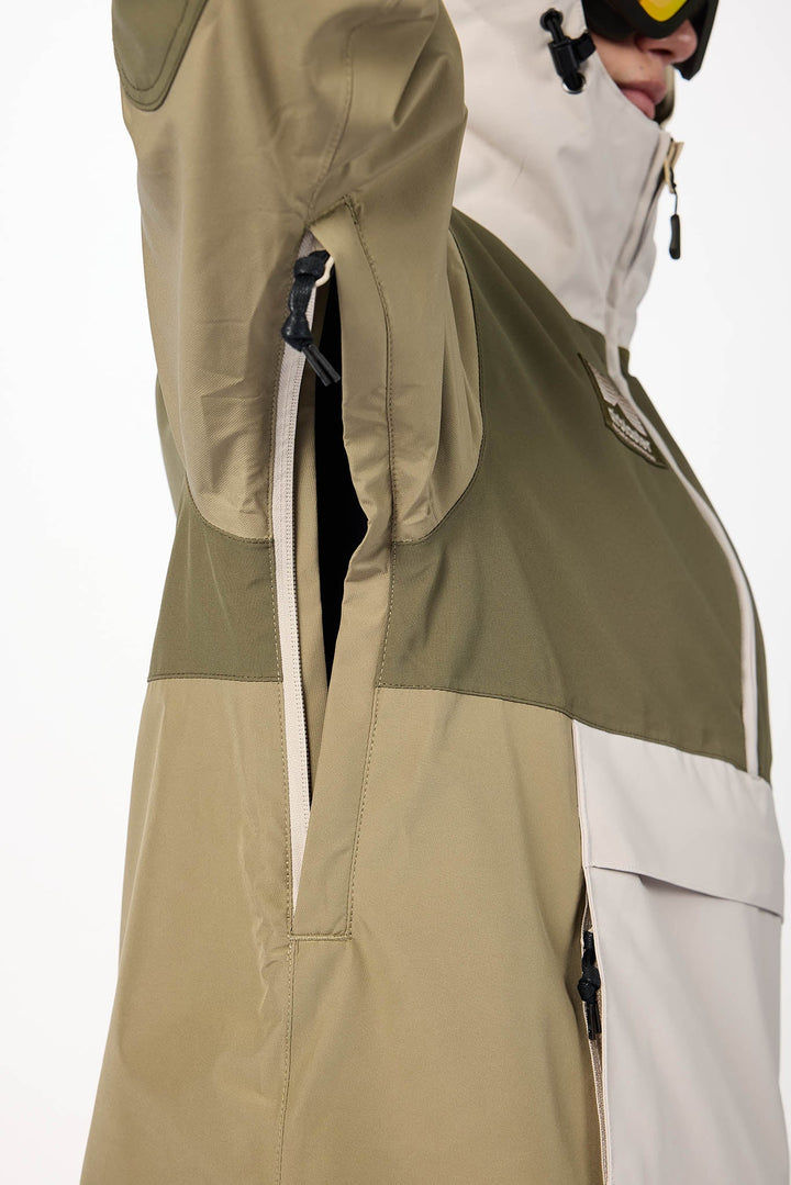 Person wearing a green and beige snowboard jacket on a white background