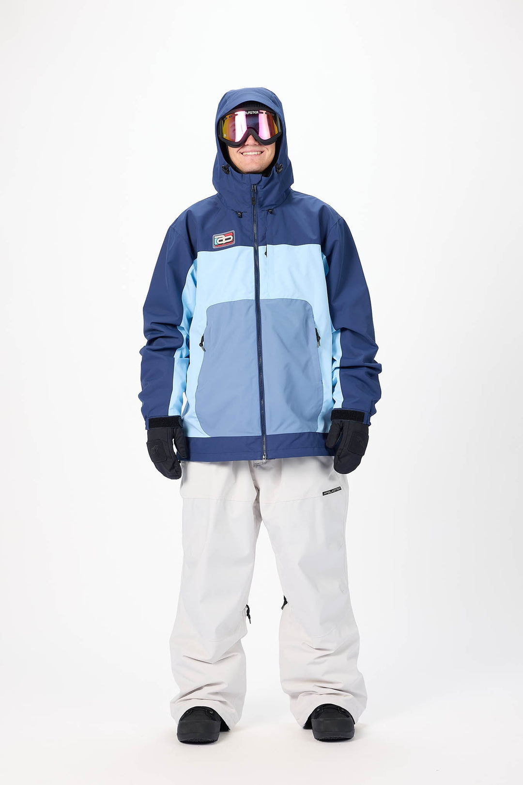Person wearing a blue and light blue snow jacket with white pants on a white background
