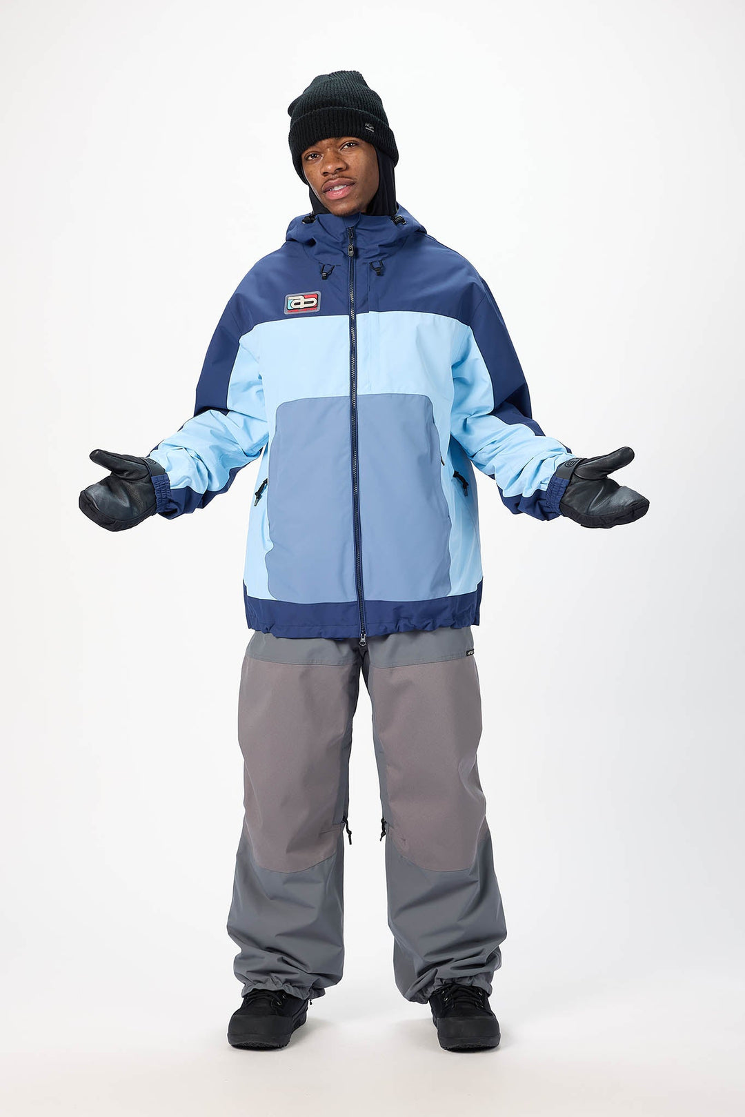 Person wearing a blue and gray snowsuit on a white background