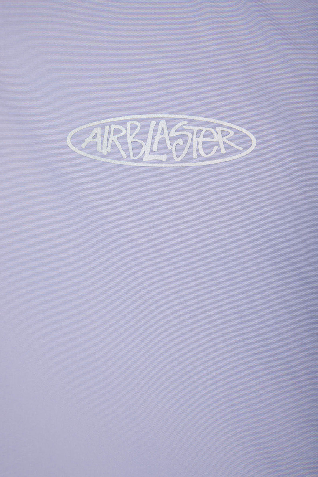 A close-up of a light lavender-purple fabric surface with a white outlined oval logo reading &