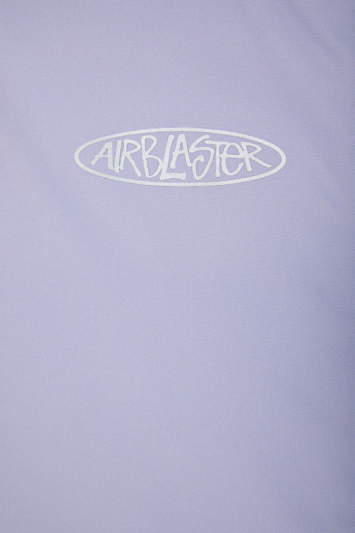 A close-up of a light lavender-purple fabric surface with a white outlined oval logo reading &