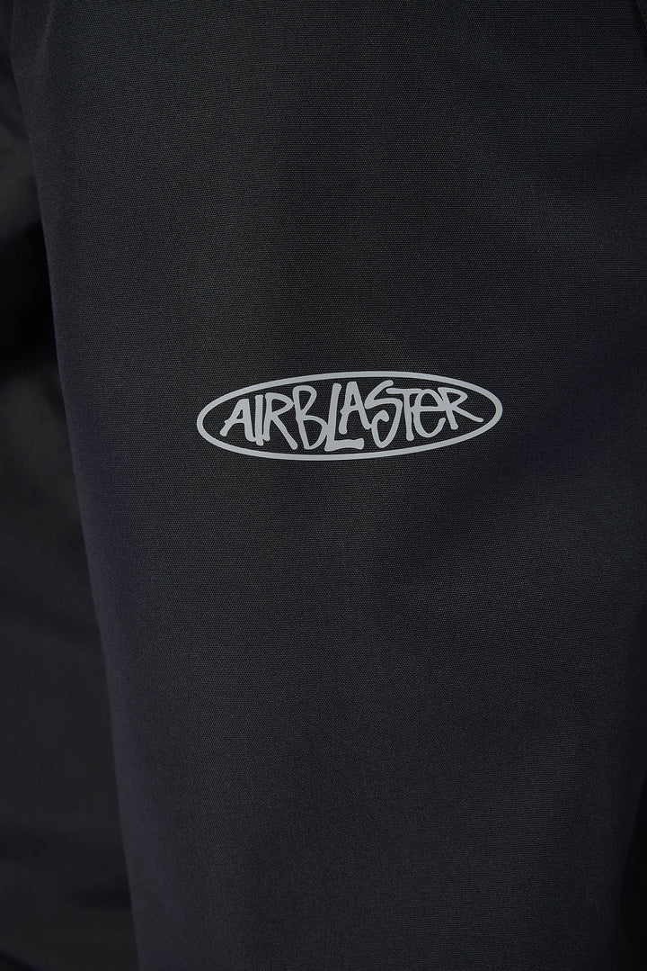 Close-up of a black garment featuring a white embroidered oval logo with the brand name &